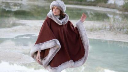 La cape Violaine dans sa version rouille signée Aline. Réalisée en laine, elle est bordée de fausse fourrure de haute qualité (85% acrylique, 15% polyester).