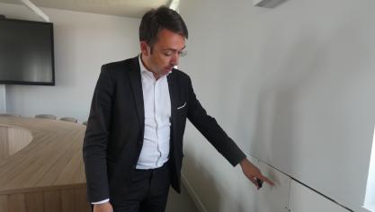 Le maire d’Arques, Benoît Roussel, devant un mur ouvert de la nouvelle salle du conseil municipal.