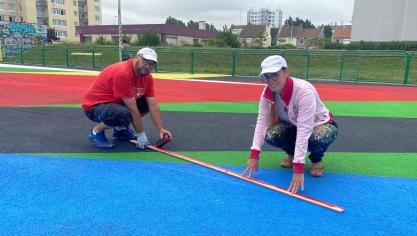 Jank et Agathe Verschaffel réalisent une fresque au sol au City stade Manet avec les habitants.