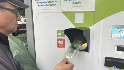 Victor passe beaucoup de temps à mettre ses bouteilles dans la machine de supermarché.