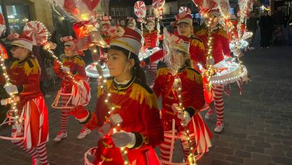 Fidèles au thème du Noël gourmand de la commune, ces jeunes défilent ornées de sucettes colorées et de lumières festives.