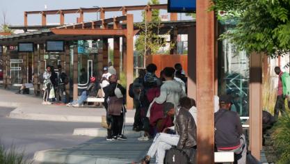 Des migrants attendant un bus à la gare routière de Calais, vendredi 25 juillet.